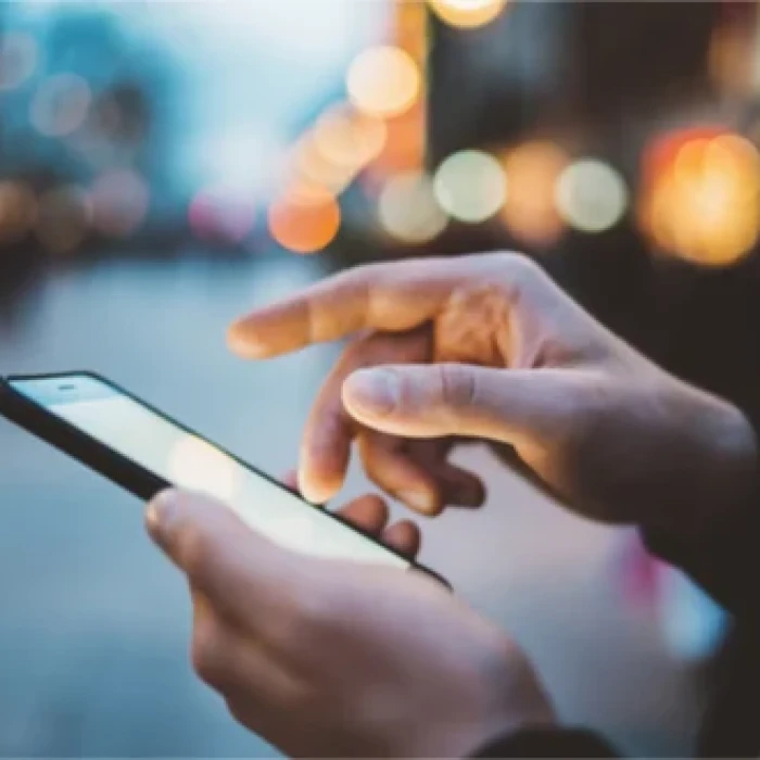 Handen die een smartphone bedienen om hun nieuwsbrief te lezen